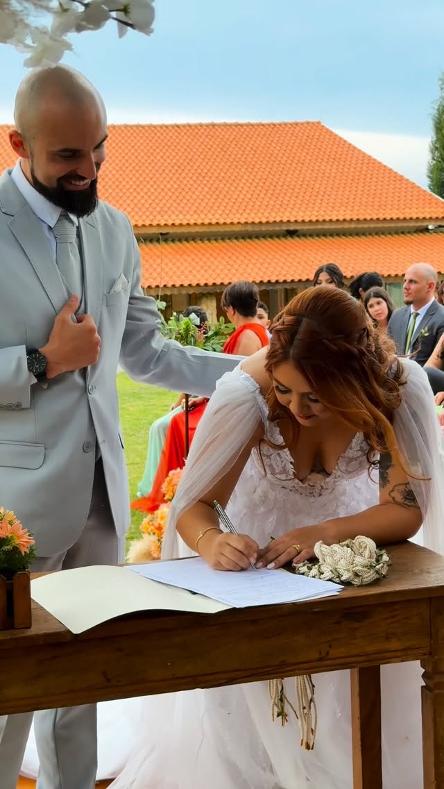 Noivos Karina e Bruno assinando os papéis durante a cerimônia de efeito civil
